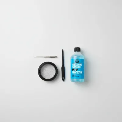 A maintenance kit for a pressure washer, including a nozzle cleaning tool, a small brush, and a water filter, displayed neatly.